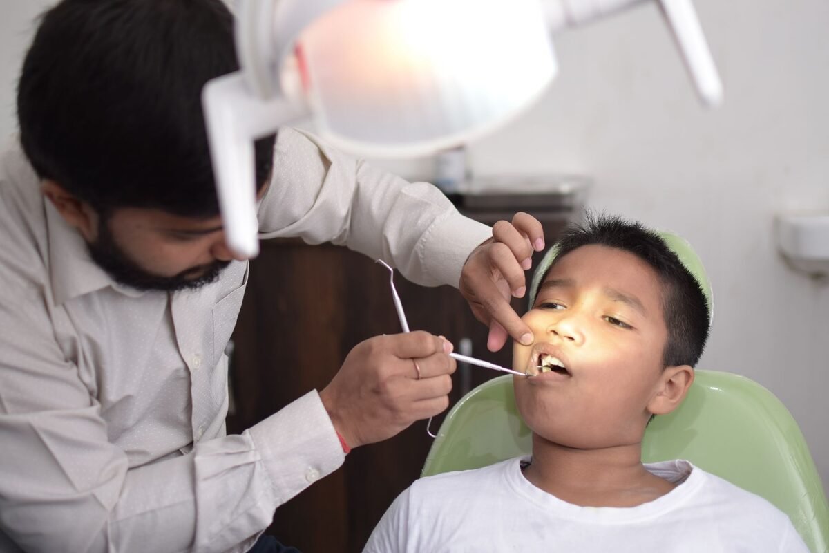 A young child smiling in the dental chair during a gentle checkup